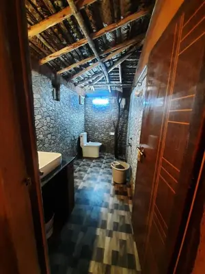 a bathroom with two sinks and a toilet in a room at Mannora Resorts Marayoor in Marayoor