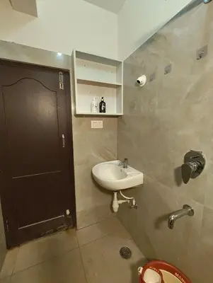 a bathroom with a sink and a black door at Luxurious 3BHK AC, Peaceful location, Premium stay in Mysore