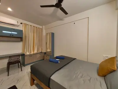 a bedroom with a bed and a ceiling fan at Luxurious 3BHK AC, Peaceful location, Premium stay in Mysore