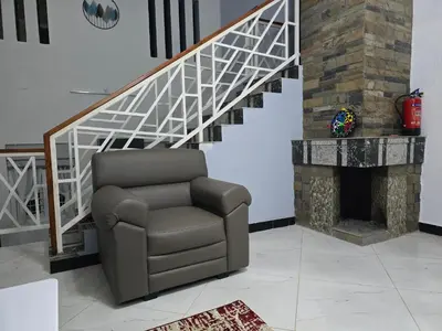 a reclining chair in a living room with a staircase at Nest Resort in Ketti