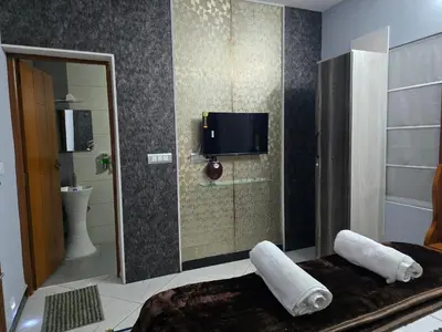 a bathroom with a tv on a wall with towels at Nest Resort in Ketti