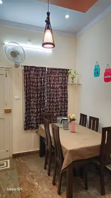 a dining room with a wooden table and chairs at JEO Home Stay And Hospitality in Mysore