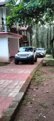 two cars parked in front of a house at Coorg Namana homestay in Suntikoppa