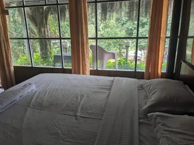 a bedroom with a bed and a large window at Ashokavanam Heritage Village by N Square in Kanthalloor