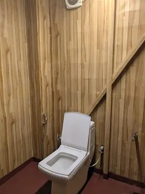 a toilet in a bathroom with wooden walls at Ashokavanam Heritage Village by N Square in Kanthalloor