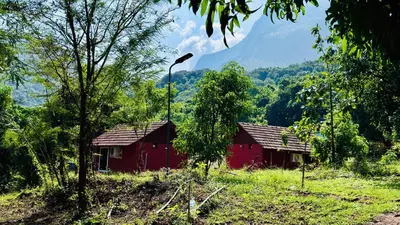 a red house in the middle of a forest at Jungle Homes in Kollengode