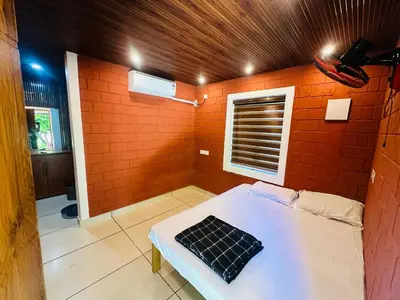 a room with a bed in a brick wall at Jungle Homes in Kollengode
