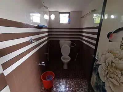a bathroom with a toilet in a room with stripes at Jungle View Homestay Anakulam in Viripara