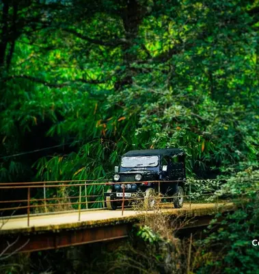 a truck on a bridge with trees in the background at Jungle View Homestay Anakulam in Viripara