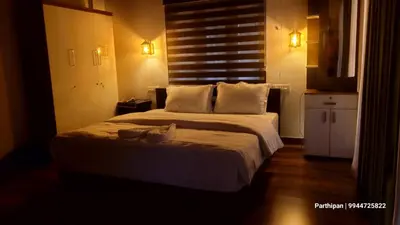 a bedroom with a bed with a cat sitting on it at Heaven Crest Holidays and Plantations in Chithragiri