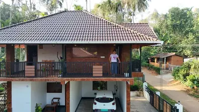 a man standing on the balcony of a house at Heaven Crest Holidays and Plantations in Chithragiri