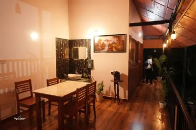 a dining room with a table and a person taking a picture at Heaven Crest Holidays and Plantations in Chithragiri