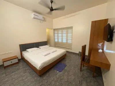 a bedroom with a large bed and a window at Keshavam Homestay in Guruvāyūr