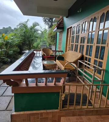 a balcony with a table and chairs on a house at Wayanad views in Vythiri
