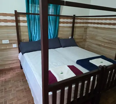 a bedroom with a wooden bunk bed with blue curtains at Wayanad views in Vythiri