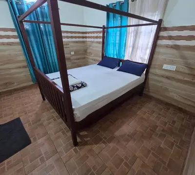 a bedroom with a canopy bed in a room at Wayanad views in Vythiri