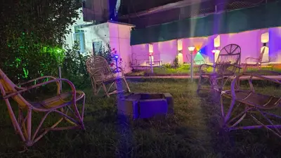 a group of chairs in a yard with purple lights at Nature View Private Villa in Ooty