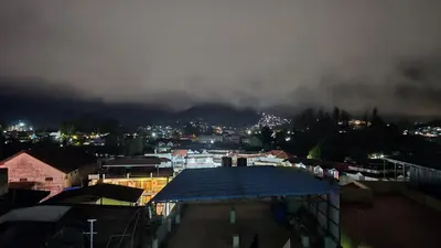 a view of a city at night with a mountain at Nature View Private Villa in Ooty