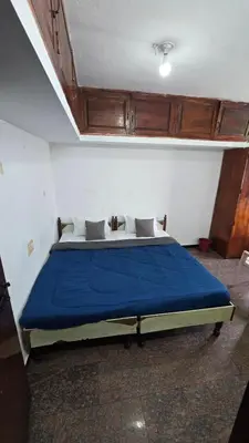 a bedroom with a large bed with blue sheets at Nature View Private Villa in Ooty