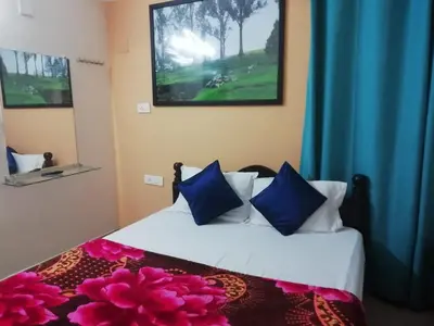 a bedroom with two beds with blue curtains at Queenhill Apartment in Ooty