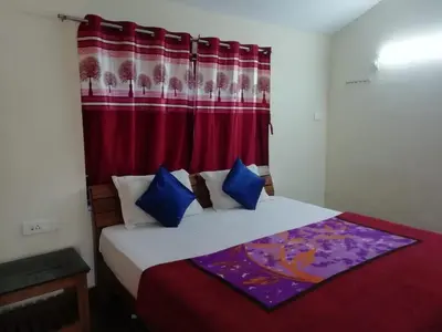 a bedroom with a bed with a red curtain at Queenhill Apartment in Ooty