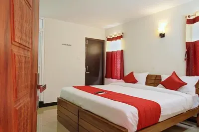 a bedroom with a large bed with red curtains at Queenhill Apartment in Ooty