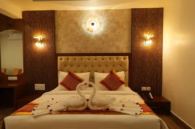 two swans made out of towels on a bed at Captains Crown Hotels & Resorts in Kushālnagar