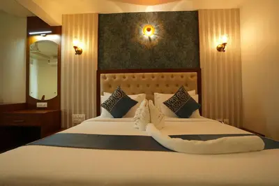 a bedroom with a large white bed with a mirror at Captains Crown Hotels & Resorts in Kushālnagar
