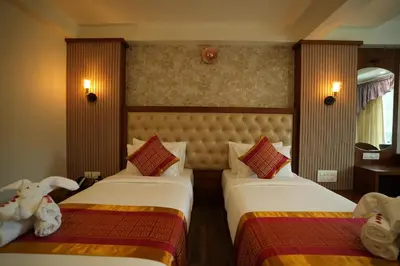 a hotel room with two beds and a window at Captains Crown Hotels & Resorts in Kushālnagar