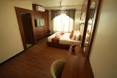 a hotel room with a bed and a mirror at Captains Crown Hotels & Resorts in Kushālnagar