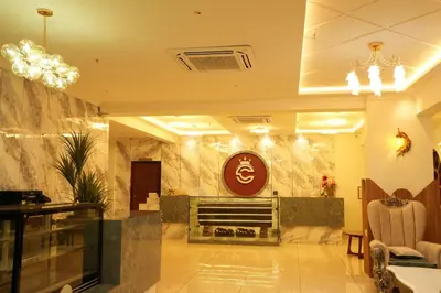 a lobby with a fireplace and a sign on the wall at Captains Crown Hotels & Resorts in Kushālnagar