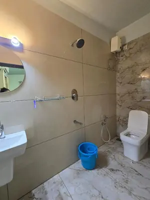 a bathroom with a sink and a toilet and a mirror at Rivulet Dale in North Paravur