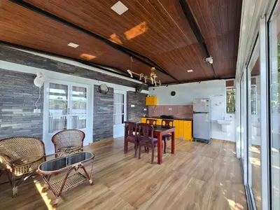 a dining room with a table and chairs and a kitchen at Rivulet Dale in North Paravur