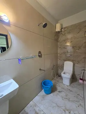 a bathroom with a white toilet and a sink at Rivulet Dale in North Paravur