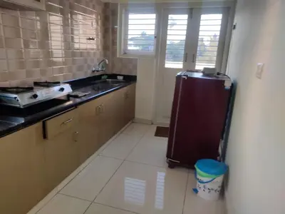 a kitchen with a refrigerator and a sink at Brindavan Service Apartments in Mysore