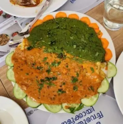 a plate of food with green sauce and cucumbers at AE Tower Platinum Retreat in Sultan Bathery
