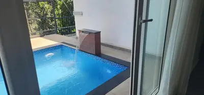 a swimming pool with a fountain in a house at Itria private pool villa in Pinangode