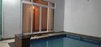 a swimming pool with a window in a building at Itria private pool villa in Pinangode