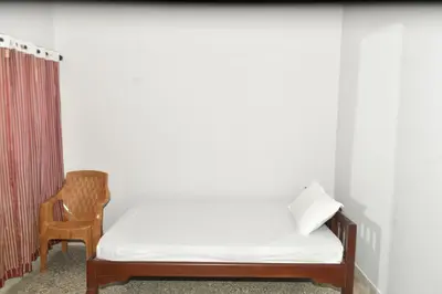 a bed and a chair in a room at Pepper Nut Homestay in Thattakād