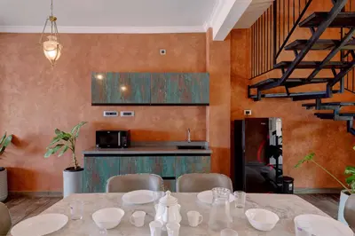 a dining room with a table and a kitchen at Bougainvillea Beach Home - Guruvayur - Chavakkad in Manattala