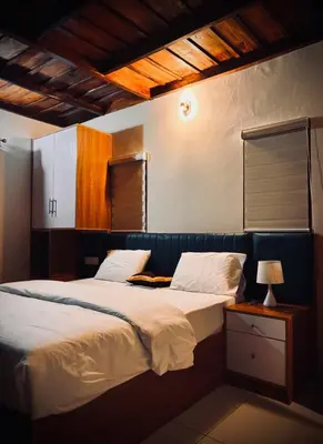 a bedroom with two beds and a table with a lamp at Riparian Inn Resort in Chekadi