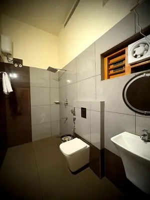 a bathroom with a toilet and a sink at Riparian Inn Resort in Chekadi