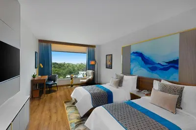 a hotel room with two beds and a flat screen tv at Fortune Airport Road Kochi - Member ITC hotels' group in Cochin