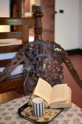 an open book on a table with a cup of coffee at Seclude Karthika Nivas, Thrissur in Trichūr