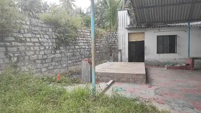 a house with a brick wall and a patio at NKM Holiday Park in Shrīrangapattana
