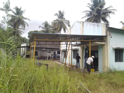 two men are standing outside of a building at NKM Holiday Park in Shrīrangapattana