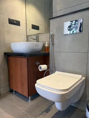 a bathroom with a white toilet and a sink at Trumpet Deck 3BHK Container Home in Kutta