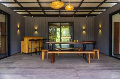 a dining room with a table and stools at Trumpet Deck 3BHK Container Home in Kutta