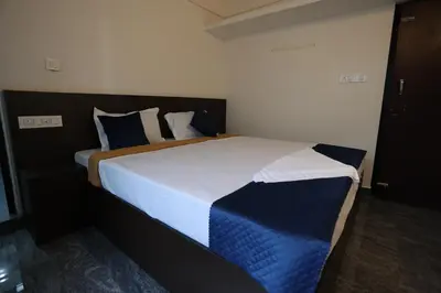 a bedroom with a large bed with blue and white sheets at Emberlin Holidays in Wayanad