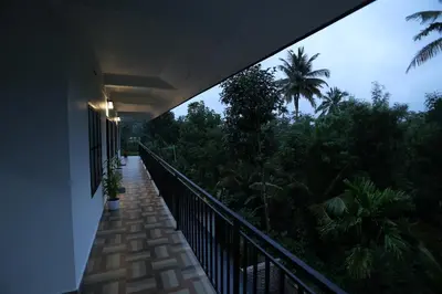 a balcony of a house with a view of trees at Emberlin Holidays in Wayanad